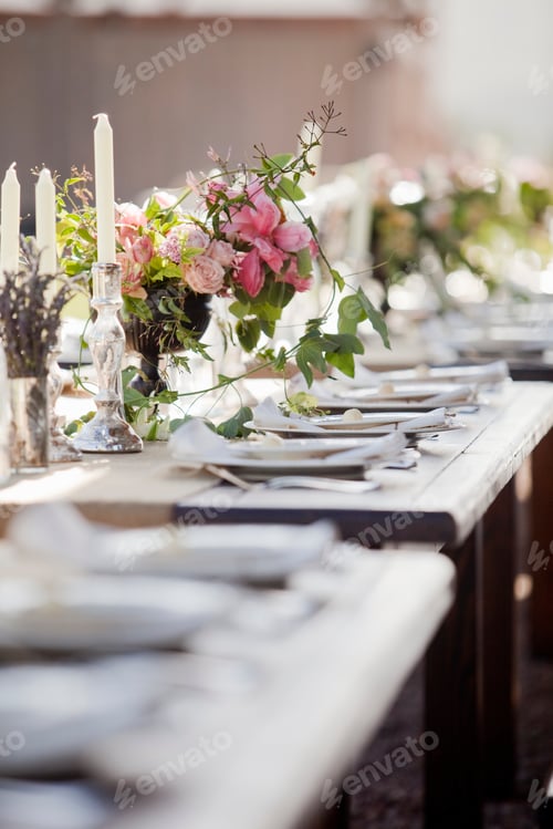 Preview: A formal wedding breakfast table, laid for a feast. Fresh flowers in the centre.