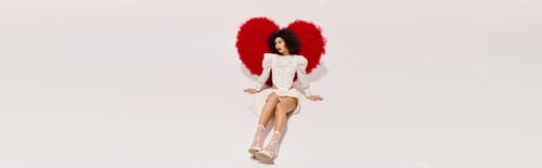 Preview: Celebrating love with a stylish young woman by a vibrant red heart