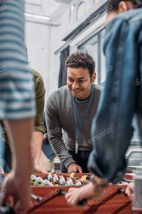 Preview: cropped image of colleagues playing in table soccer at modern office