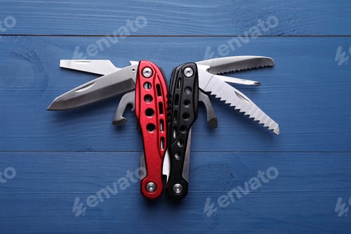 Preview: Modern compact portable multitool on blue wooden table, top view