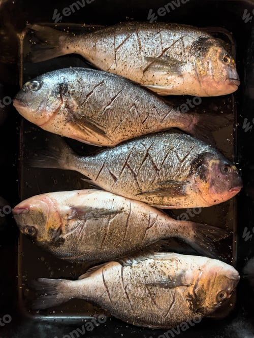 Preview: Raw spar fishes with spices lie on a tray