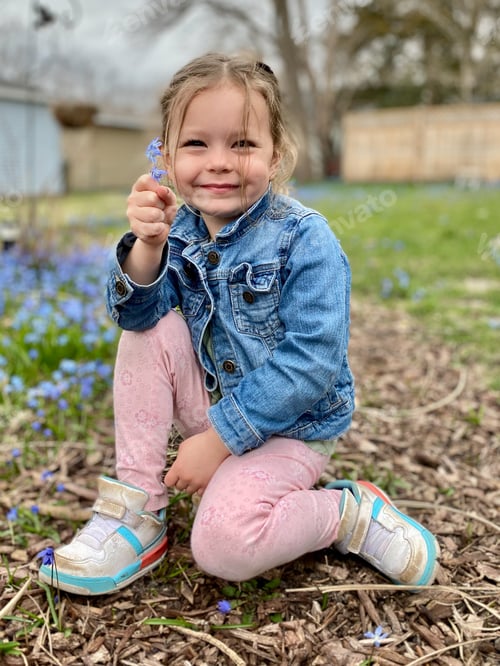 Preview: Little girl picking spring wildflowers in the backyard