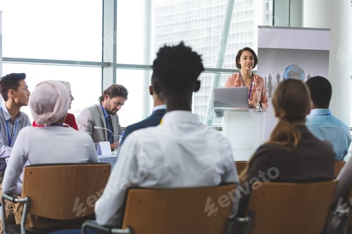 Preview: Female speaker with laptop speaking in business seminar in office building