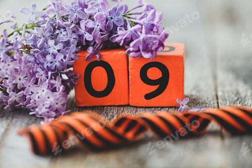 Preview: Wooden calendar with Russian text May 9, george ribbon and a bouquet of lilacs