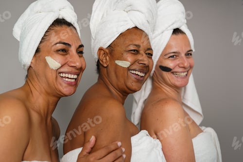 Preview: Happy multiracial women having fun together during beauty treatment skin care