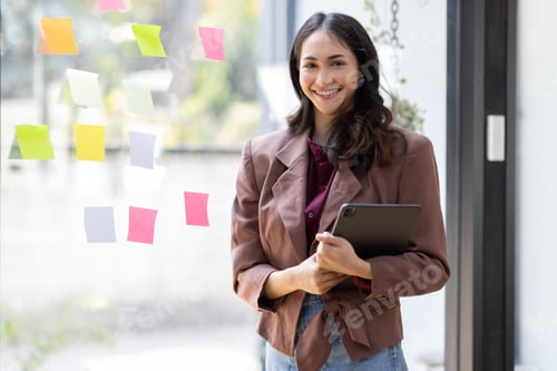 Preview: young indian girl asian woman entrepreneur of small company putting a adhesive sticky notes in glass