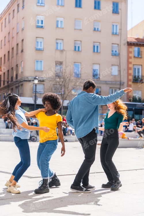 Preview: Multi ethnic young friends dancing in a city square, group of diverse friends having fun