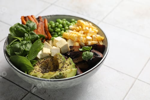 Vista previa: Healthy vegetarian food. Delicious Buddha bowl on light tiled table, closeup. Space for text