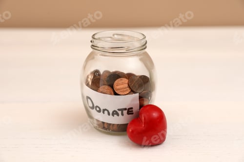 Preview: Red heart and donation jar with coins on table