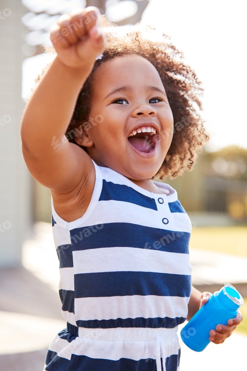 Preview: Young black girl blowing bubbles outside her home