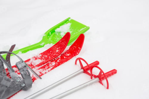 Preview: Children's red skis with sticks and a green snow shovel -layout in the snow