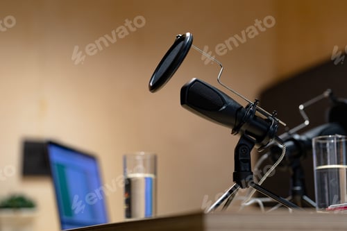 Preview: Office desk with microphones, laptop computer and glasses of water