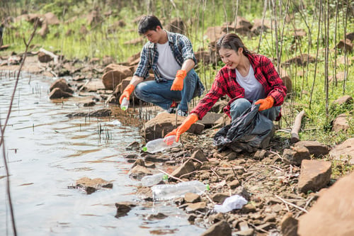 Preview: Men and women help each other to collect garbage.