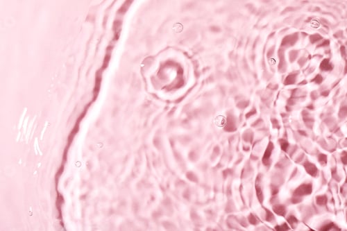 Preview: Closeup view of water with rippled surface on pink background