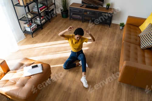 Preview: Excited young woman sitting on the floor at home