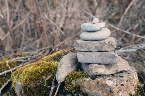 Preview: Round river rocks stacked on the edge of a road.