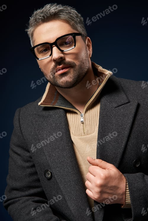 Preview: Stylish man in glasses showcases elegance in a modern fashion studio setting