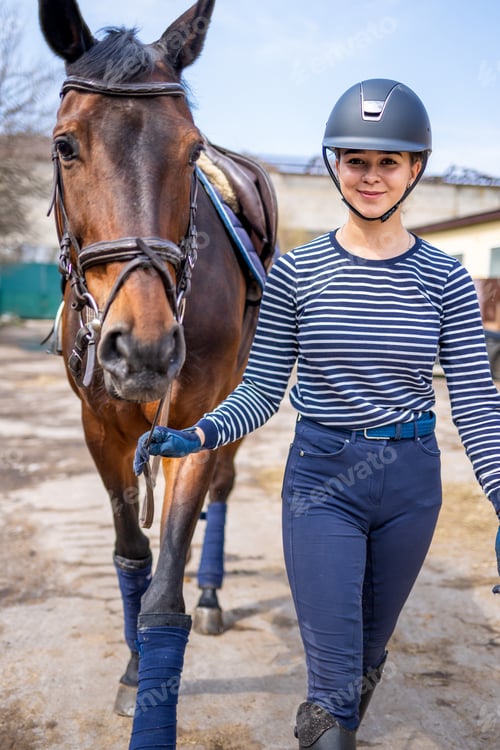 Preview: Young jockey teen girl walking with the horse before training