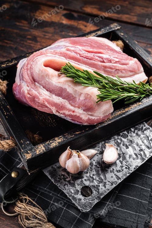 Vista previa: Organic uncooked Pork belly, raw bacon meat in a wooden plate with thyme.