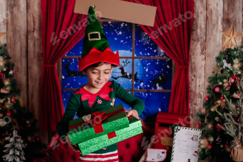 Preview: Joyful child in an elf costume opens a gift in a festive Christmas setting