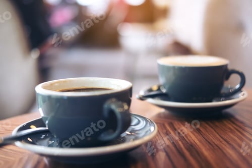 Preview: two blue cups of hot latte coffee and Americano coffee on vintage wooden table in cafe