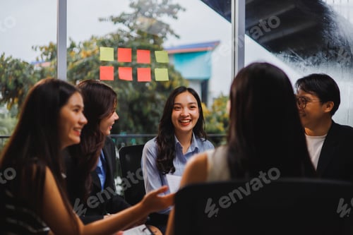 Preview: Asian businesspeople discussing during a meeting in a modern office