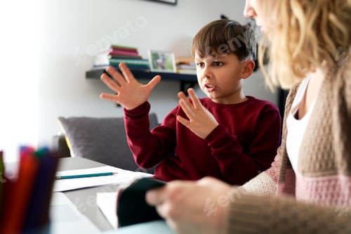 Preview: Boy gesturing during doing homework with his mother