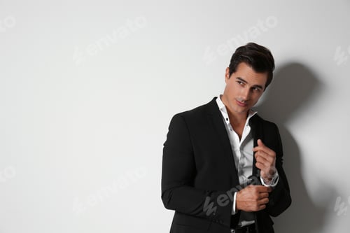 Preview: Handsome young man in elegant suit on light beige background. Space for text