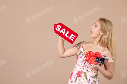 Preview: front view young female holding red present sale nameplate and bank card on brown background money