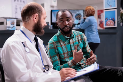 Preview: General practitioner talking to male patient in waiting room