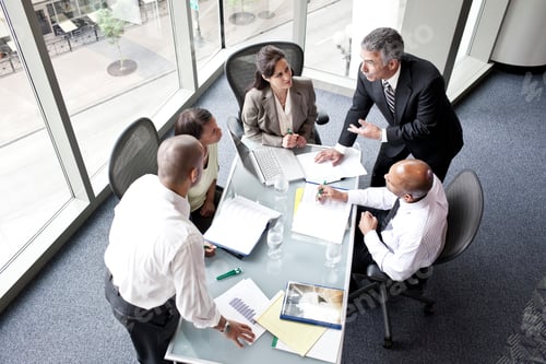 Preview: Male and female business people in a meeting at a conference table, overhead view