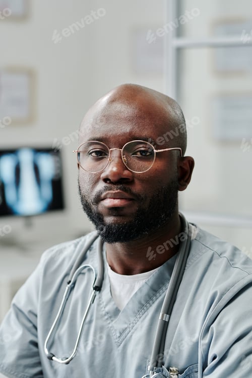 Preview: Young confident black man in blue uniform and eyeglasses looking at camera