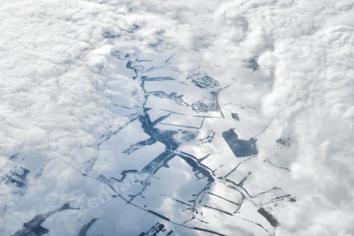 Preview: Aerial cloudscape view over clouds top to snow covered rivers, roads, cities and fields, winter air