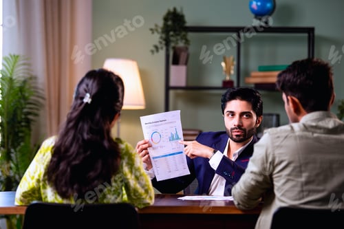 Visualização: Young Indian husband and wife analyzing financial reports with planner in office
