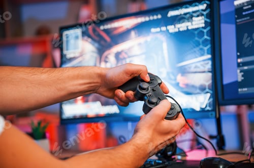 Preview: Close up view of hands with joystick controller. Male game streamer in casual clothes is indoors