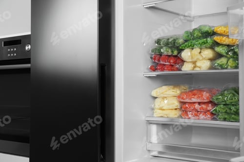 Preview: Plastic bags with different frozen vegetables in refrigerator indoors