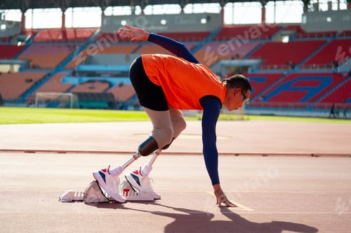 Preview: Asian para-athletes with prosthetic blades sprint on a running track at stadium.