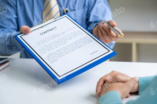 Preview: Male arm in shirt offers contract form on clipboard pad and silver pen to sign closeup. sale insura