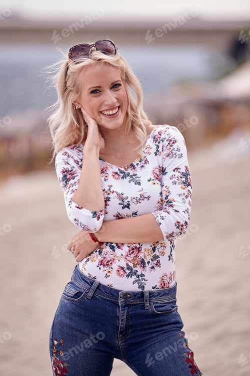 Preview: Carefree Portrait, One Young Woman, 25 Years Old, Floral Pattern Top, Jeans. Looking Down, Smiling