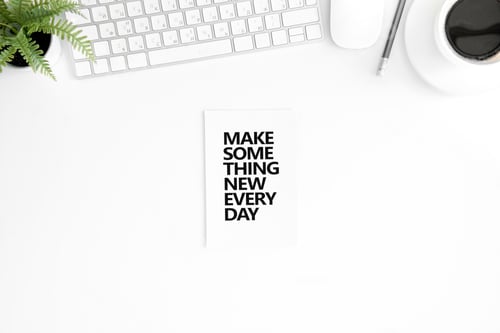 Preview: flat lay with make something new every day motivational quote in diary, computer mouse and keyboard