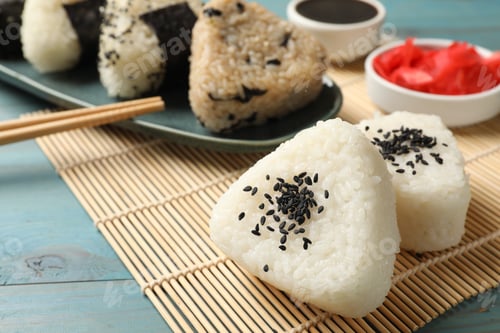 Preview: Rice balls (onigiri) served on light blue wooden table, closeup. Traditional Japanese dish