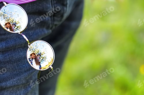 Preview: Defocus circle sunglasses. Reflection on mirror. Young funny woman outside. Spring nature background