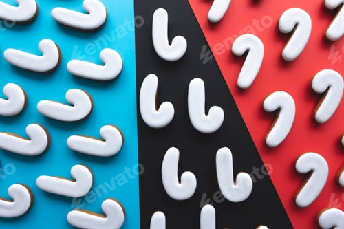 Preview: A lot of gingerbread candy cane shaped cookies on a colored background.