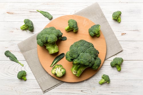 Preview: fresh green broccoli on wooden cutting board with knife.