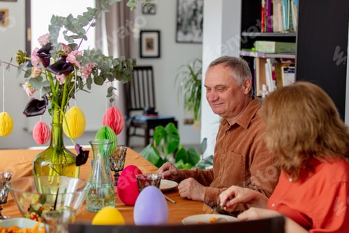 Preview: Grandpa and grandma eating at Easter dinner sitting at the table at home