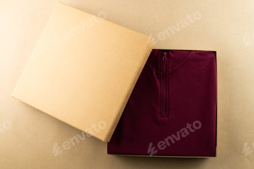 Preview: Close up of red sweatshirt in packaging and copy space on yellow background