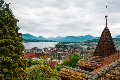 Preview: Scenic view of Lucerne city with Lake Lucerne and Swiss Alps in the background on a cloudy day