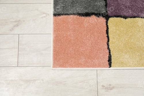 Preview: Soft carpet with pattern on white laminated floor indoors, top view
