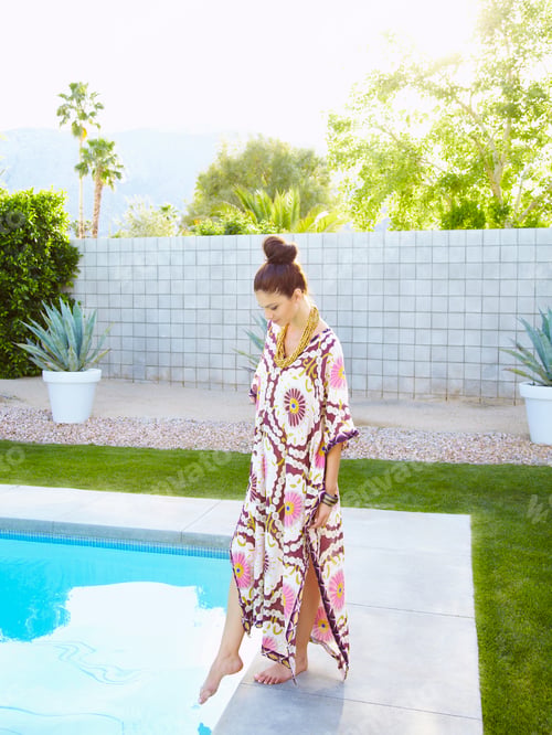 Preview: Young woman in a long colourful kaftan dress.