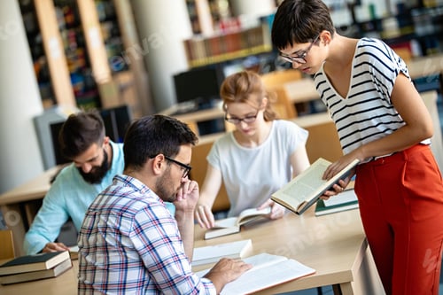 Preview: Happy university students studying with books in library. Group of multiracial people in college